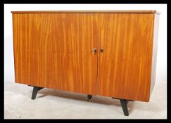A 1970's retro teak wood metamorphic sideboard desk cabinet. Raised on tapered supports with a 3/4