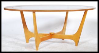 A vintage 20th century teak wood G-Plan style Astral coffee table of oval form with inset glass