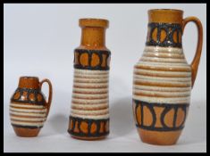 A group of three West German retro 20th century matching graduating fat lava ewers / water jugs