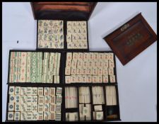 A Chinese Mah Jong set, complete with 144 bamboo backed bone tiles, representing dragons, winds,