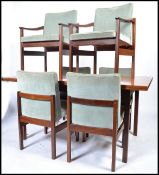A 1970's believed Heals of London teak wood dining table and 6 chairs - suite. Raised on squared
