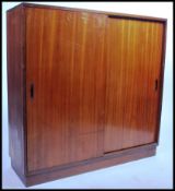 A large teak mid century Industrial 1950's filing cabinet cupboard having sliding doors and internal