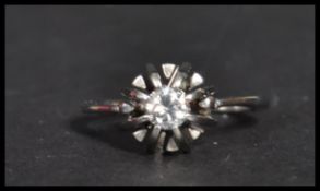 A white gold single stone diamond ring. The centra
