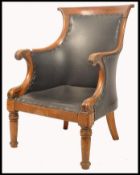 A 19th century Regency oak & frutiwood library armchair raised on turned legs with scalloped