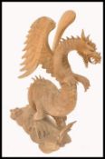 A fine and unusual 20th century large hand carved wooden figurine of a dragon being raised  on  a