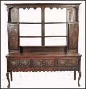 An 18th / 19th century country oak dresser being raised on shaped legs with a series of short