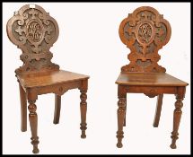 A good pair of 19th century Victorian solid oak armoiral carved hall chairs being raised on turned