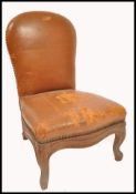 A 19th century oak and leather gout stool in the form of a French fauteuil. The seat and back rest