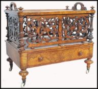 A high Victorian burr walnut  canterbury being raised on turned legs with white ceramic castors