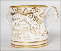 A 19th century Staffordshire twin handled loving cup being adorned with gilt notation ' A Present