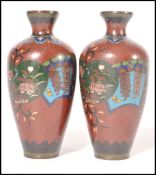 A pair of 19th century cloisonne miniature Japanese vases having red ground with blue panels and