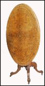A 19th century Victorian walnut inlaid decorated tilt top pedestal dining table. Raised on a