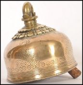 A 19th century Indian brass cow bell having chased ring decoration. The bell of traditional shape