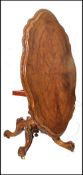 An exceptional 19th century walnut tilt top breakfast table being raised on stunning splayed legs