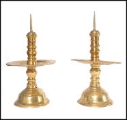 A pair of Dutch brass pricker candlesticks, possibly 17th century being raised on terraced base with