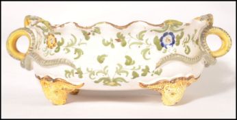 A 19th century continental Faience twin handled fruit bowl raised on rams head feet with