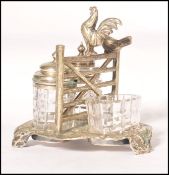 A 19th century novelty silver plated cruet set featuring two birds standing on a fence gate with two