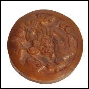 A Chinese Jade roundel seal of mottled brown colour carved with scrolling dragon motif and geometric