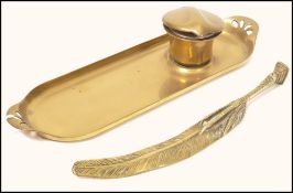 A 19th century brass pen tray with fitted inkwell having a top hat ceramic liner with feather and