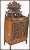 A 19th century Chinese hardwood table cabinet. Profusely carved with pierced detailing to the