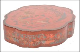 A good early 20th century Japanese large red and gold lacquer lozenge shaped box with scrolling
