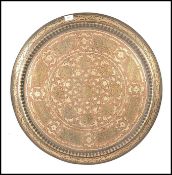 A large 19th century Indian brass and copper wall charger of roundel form with raised gallery edges.