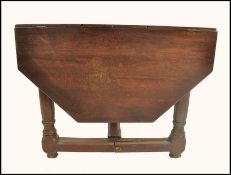 An 18th century country oak hexagonal drop leaf gate leg dining table. Raised on gun barrel thick