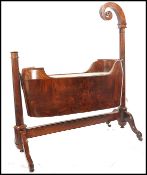 A 19th century Biedermeier cradle cot in a stunning walnut being raised on splayed legs with brass