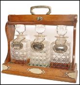A 19th century Victorian triple decanter oak Tantalus raised on a plinth base with silver plated