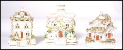 A group of 3 19th century flower encrusted pastille burners in the shape of cottages to include a