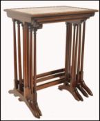 A 19th century mahogany inlaid nest of tables being raised on faux bamboo supports on splayed legs