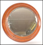 A late Victorian circular mahogany bevelled edge wall mirror of cushion form , the back with