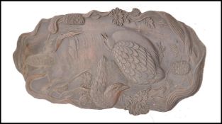 A Meiji period Japanese bronze pen tray modelled in relief with nesting birds flowers and leaves.