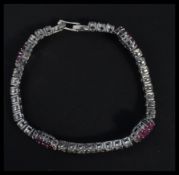 A sterling silver and ruby set cz line bracelet wi