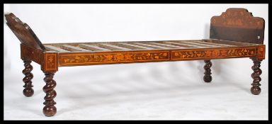 A 19th century continental mahogany and marqetry inlaid daybed bed. Raised on barley twist legs with