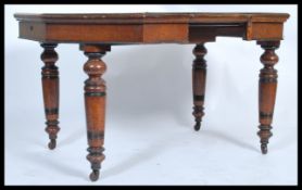 A 19th century Victorian octagonal oak winding dining table raised on turned legs complete with