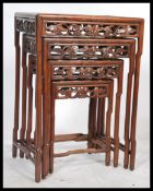 An early 20th century hardwood nest of four tables quartet. Raised on circular legs with