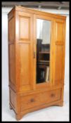 A Victorian oak panelled wardrobe having a single mirrored door raised on a deep long drawer base