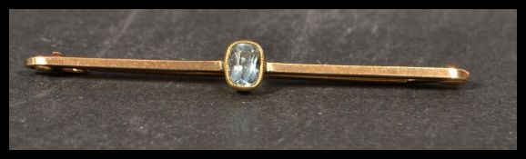 A 9ct gold bar brooch set with an oval cut pale blue stone. Tests 9ct gold. Measures 5cms. Weight