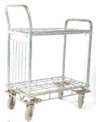 A vintage retro industrial shops tote / shop assistants metal tubular trolley. Having two wire mesh