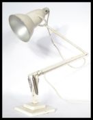 A 1940's Industrial pre-war Herbert Terry anglepoise lamp, raised on a cast metal two step base with
