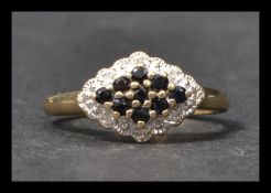 A hallmarked 9ct gold sapphire and diamond cluster ring. Hallmarked Sheffield. Weight 2.5g. Size P.