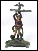 A 20th century cast iron stand the back-plate modelled as a man with entwined foliage upon a