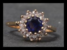A hallmarked 9ct gold white and blue stone ring set with a central round brilliant cut blue stone