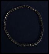 A hallmarked 9ct gold and diamond bracelet being set with baguette and trapezoid cut diamonds stones