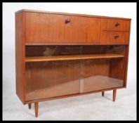 A good vintage 1970's retro teak wood library bookcase cabinet raised on tapered legs with  glass