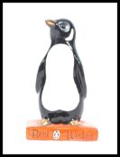 A Royal Doulton figure of a Penguin standing on a book titled 