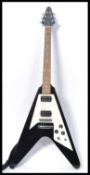 A Jaxville flying V electric guitar musical instrument. Shaped iconic body with chrome tuning