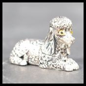 A sterling silver figurine of a poodle dog modeled on a seated position stamped sterling to base.