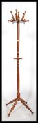 A vintage 20th century antique style hat coat stand of unusual form with bobbin turned legs supports